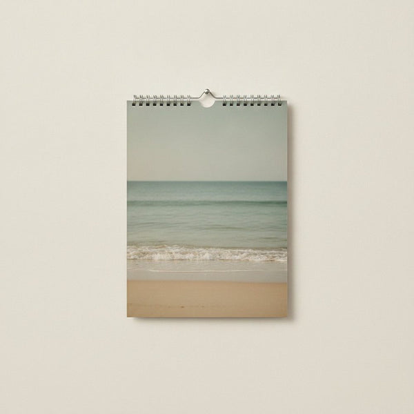 Wandkalender im Format A4 hochkant, Kalenderseite zeigt eine ruhige Strandszene mit Meer und Sand